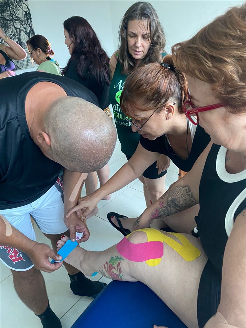 Alunos praticando aplicação de kinesiotape na perna e no pé